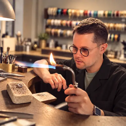 Artisan joaillier travaillant au chalumeau dans l’atelier