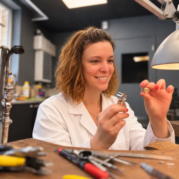 Éloïse examinant un bijou à l’atelier